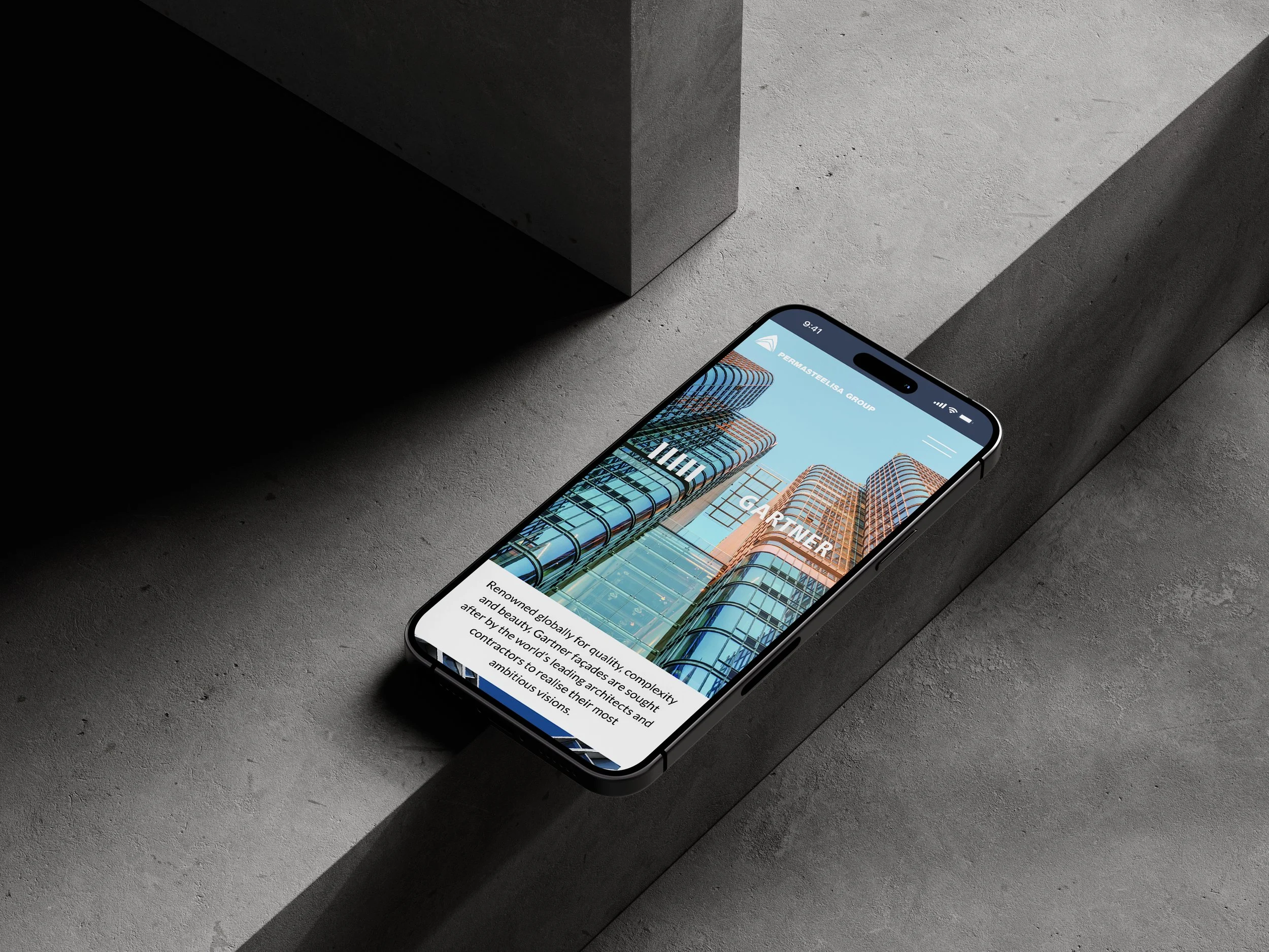 The new Permasteelisa Group website shown on a smartphone against a curtain-wall façade backdrop